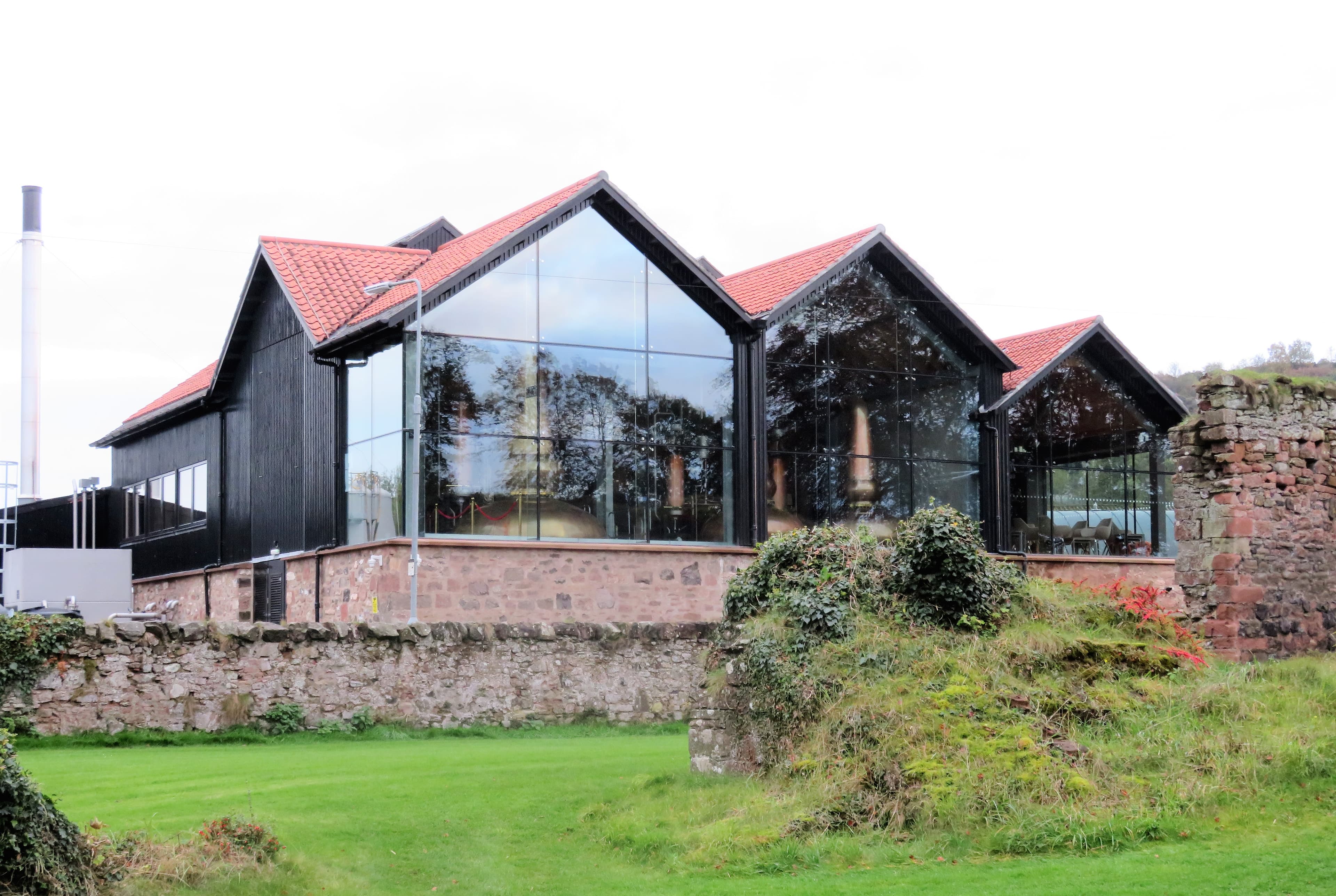 Lindores Abbey Distillery's glass-fronted still house behind the abbey ruins