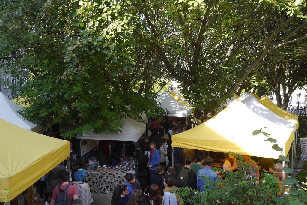 Yellow gazebos of Stockbridge Market under the trees on Saunders Street, Edinburgh